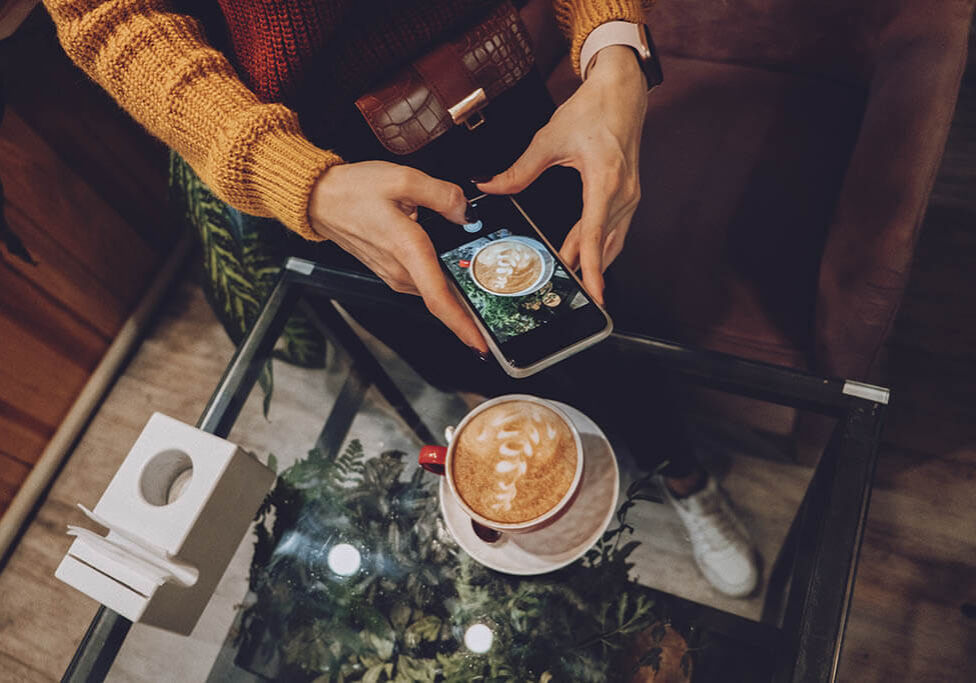 Support small businesses concept. Small Businesses Need Support, Shop Local. The cafe small-business owner takes pictures of coffee and food for online delivery.